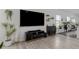 Contemporary living space with wood-look flooring, a TV, and stylish shelving at 10459 Ladybug Cove, Parrish, FL 34219
