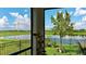 Charming screened patio overlooking a tranquil lake, enhanced with potted plants and a peaceful outdoor setting at 10459 Ladybug Cove, Parrish, FL 34219
