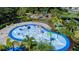 Aerial view of a splash pad with playground in the background, surrounded by landscaping at 10459 Ladybug Cove, Parrish, FL 34219