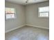 Bright bedroom with neutral decor, tile flooring, and natural light from two windows, creating a cozy retreat at 110 Pine Ave, Osprey, FL 34229