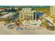 Breathtaking aerial view of beachfront condos with palm trees, a pool and a sandy beach at 1104 Benjamin Franklin Dr # 519, Sarasota, FL 34236