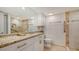 Bathroom with granite countertops, white cabinets, and a walk-in shower with tiled walls at 1104 Benjamin Franklin Dr # 519, Sarasota, FL 34236