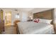 Inviting bedroom with a large bed, wood flooring, and a view into the attached bathroom at 1104 Benjamin Franklin Dr # 519, Sarasota, FL 34236