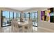 Elegant dining area with a modern table set, sliding glass doors to balcony, and beautiful artwork at 1104 Benjamin Franklin Dr # 519, Sarasota, FL 34236