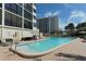 Outdoor pool surrounded by lounge chairs and lush landscaping, perfect for relaxation at 1104 Benjamin Franklin Dr # 519, Sarasota, FL 34236