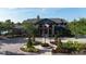 Exterior of community clubhouse with lush landscaping and flagpole at 11252 Fieldstone Dr, Palmetto, FL 34221