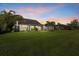 Beautiful backyard featuring well-maintained lawn and mature landscaping at sunset at 11420 Golden Bay Pl, Bradenton, FL 34211