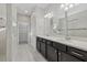 Bathroom featuring dual vanities, walk-in shower and access to walk-in closet at 11420 Golden Bay Pl, Bradenton, FL 34211