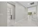 Open hallway leads to bathroom and main living area with tile floors and light gray paint at 11420 Golden Bay Pl, Bradenton, FL 34211