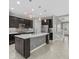 Modern kitchen with island, stainless steel appliances, dark wood cabinets, and stylish backsplash at 11420 Golden Bay Pl, Bradenton, FL 34211