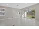 Bright living room showcasing tile flooring, neutral walls, and sliding glass doors to the outdoor area at 11420 Golden Bay Pl, Bradenton, FL 34211