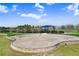 Community amphitheater featuring terraced seating and a stage area overlooking a park with playground and walking path at 11421 Carlton Fields Dr, Riverview, FL 33579