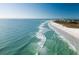Scenic aerial view of a pristine white sand beach with turquoise water and a clear blue sky at 1240 Dolphin Bay Way # 304, Siesta Key, FL 34242