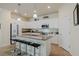 This spacious kitchen includes pendant lighting, granite counters, white cabinets, and stainless appliances at 12616 Richezza Dr, Venice, FL 34293