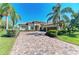 Beautiful single Gathering home showcasing a brick paver driveway, manicured lawn and tropical landscaping at 13107 Bridgeport Xing, Lakewood Ranch, FL 34211
