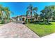 Beautiful single Gathering home showcasing a brick paver driveway, manicured lawn and tropical landscaping at 13107 Bridgeport Xing, Lakewood Ranch, FL 34211