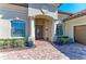 Charming front entrance featuring brick pavers, decorative columns, and lush landscaping offering curb appeal at 13107 Bridgeport Xing, Lakewood Ranch, FL 34211