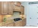 Gourmet kitchen features wooden cabinetry, granite counters, tile backsplash, and stainless steel gas cooktop at 13107 Bridgeport Xing, Lakewood Ranch, FL 34211