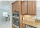 Gourmet kitchen features wooden cabinetry, granite counters, and stainless steel built in double ovens at 13107 Bridgeport Xing, Lakewood Ranch, FL 34211