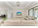 Open-concept living room featuring tile flooring, stylish furnishings, and ample natural light from large windows at 13107 Bridgeport Xing, Lakewood Ranch, FL 34211