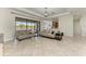 Spacious living room with neutral-toned couches, sliding glass doors overlooking the pool, and an elegant chandelier at 13107 Bridgeport Xing, Lakewood Ranch, FL 34211