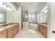 Spacious main bathroom featuring dual vanities, tub, a tile shower and neutral paint at 13107 Bridgeport Xing, Lakewood Ranch, FL 34211