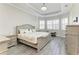 Main bedroom with tray ceilings, wood-look floors, neutral walls and trim, and plenty of natural light at 13107 Bridgeport Xing, Lakewood Ranch, FL 34211