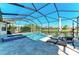 Screened pool and spa area overlooking the lake with travertine tile and lounge chairs at 13107 Bridgeport Xing, Lakewood Ranch, FL 34211