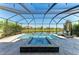 Screened pool and spa area overlooking the lake with travertine tile and lounge chairs at 13107 Bridgeport Xing, Lakewood Ranch, FL 34211
