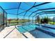 Screened pool and spa area overlooking the lake with travertine tile and lounge chairs at 13107 Bridgeport Xing, Lakewood Ranch, FL 34211