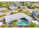 Aerial view featuring a private pool and lush landscaping backing up to a scenic lake at 1320 Magellan Dr, Sarasota, FL 34243