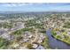 Panoramic aerial view of the community showcasing numerous homes surrounded by lush green trees and a serene lake at 1320 Magellan Dr, Sarasota, FL 34243