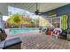 The back patio has nice brick flooring, a fan and is right next to the outdoor pool at 1320 Magellan Dr, Sarasota, FL 34243