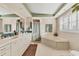 Spacious bathroom with dual vanities, a soaking tub, and modern fixtures at 1320 Magellan Dr, Sarasota, FL 34243