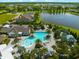 Aerial view of community pool, lake, clubhouse and surrounding landscaping at 13487 Old Creek Ct, Parrish, FL 34219
