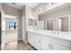Bathroom featuring double sinks, bright lighting, and a view to an adjacent bedroom at 13487 Old Creek Ct, Parrish, FL 34219
