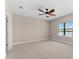 Bare bedroom featuring neutral carpet, a ceiling fan, and a bright window at 13487 Old Creek Ct, Parrish, FL 34219