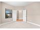Bright bedroom with neutral carpet, featuring a window with blinds and an open doorway to another room at 13487 Old Creek Ct, Parrish, FL 34219