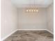 Neutral dining room with modern chandelier and wood-look tile flooring at 13487 Old Creek Ct, Parrish, FL 34219
