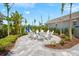 Inviting outdoor fire pit area with white Adirondack chairs and tropical landscaping at 13487 Old Creek Ct, Parrish, FL 34219