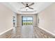 Spacious living room with wood-look tile flooring and a sliding glass door to the lanai at 13487 Old Creek Ct, Parrish, FL 34219