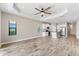 Open-concept living room with kitchen, featuring tray ceiling and wood-look tile flooring at 13487 Old Creek Ct, Parrish, FL 34219