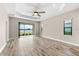 Spacious living room with tray ceiling, wood-look tile floor, and lake view at 13487 Old Creek Ct, Parrish, FL 34219