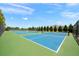 Well-maintained community tennis courts surrounded by lush landscaping and a clear blue sky at 13487 Old Creek Ct, Parrish, FL 34219