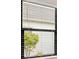 Close-up of a window with blinds, providing a view of trees and greenery outside at 13487 Old Creek Ct, Parrish, FL 34219