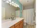 Bathroom with light blue and gray walls, a shower, and a wooden vanity with a white sink at 135 River Enclave Ct, Bradenton, FL 34212