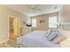 Comfortable bedroom with a ceiling fan, two windows for natural light and en-suite bathroom at 135 River Enclave Ct, Bradenton, FL 34212