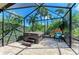 Backyard screened-in patio featuring a hot tub with tropical landscaping at 135 River Enclave Ct, Bradenton, FL 34212