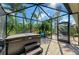 Screened in patio with a hot tub, a chair, and tropical landscaping at 135 River Enclave Ct, Bradenton, FL 34212