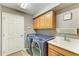 Laundry room with new blue washer and dryer, overhead cabinets, and a sink at 135 River Enclave Ct, Bradenton, FL 34212